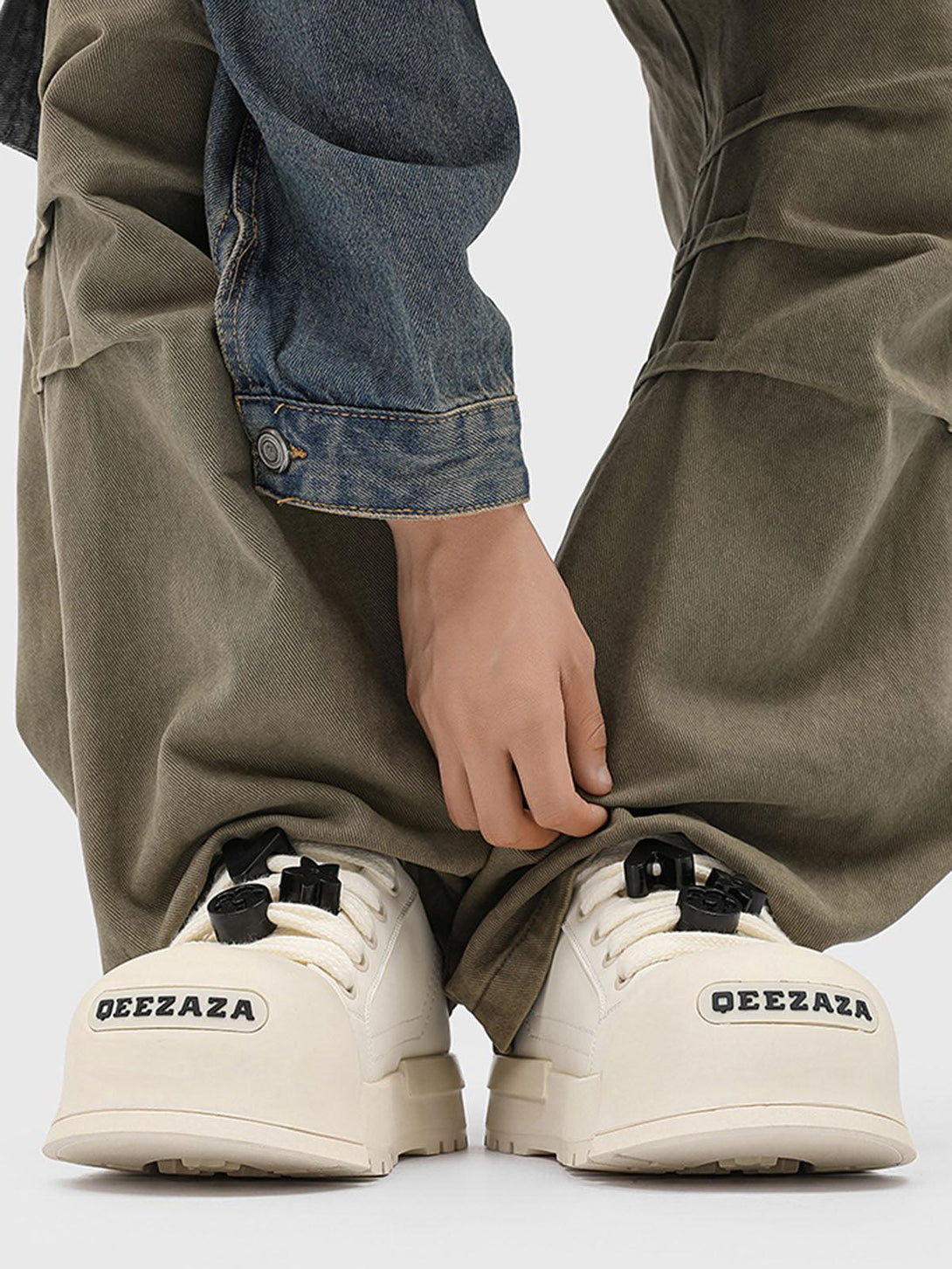 TALISHKO's monochrome chunky tread sneakers paired with denim and khaki for a bold look.