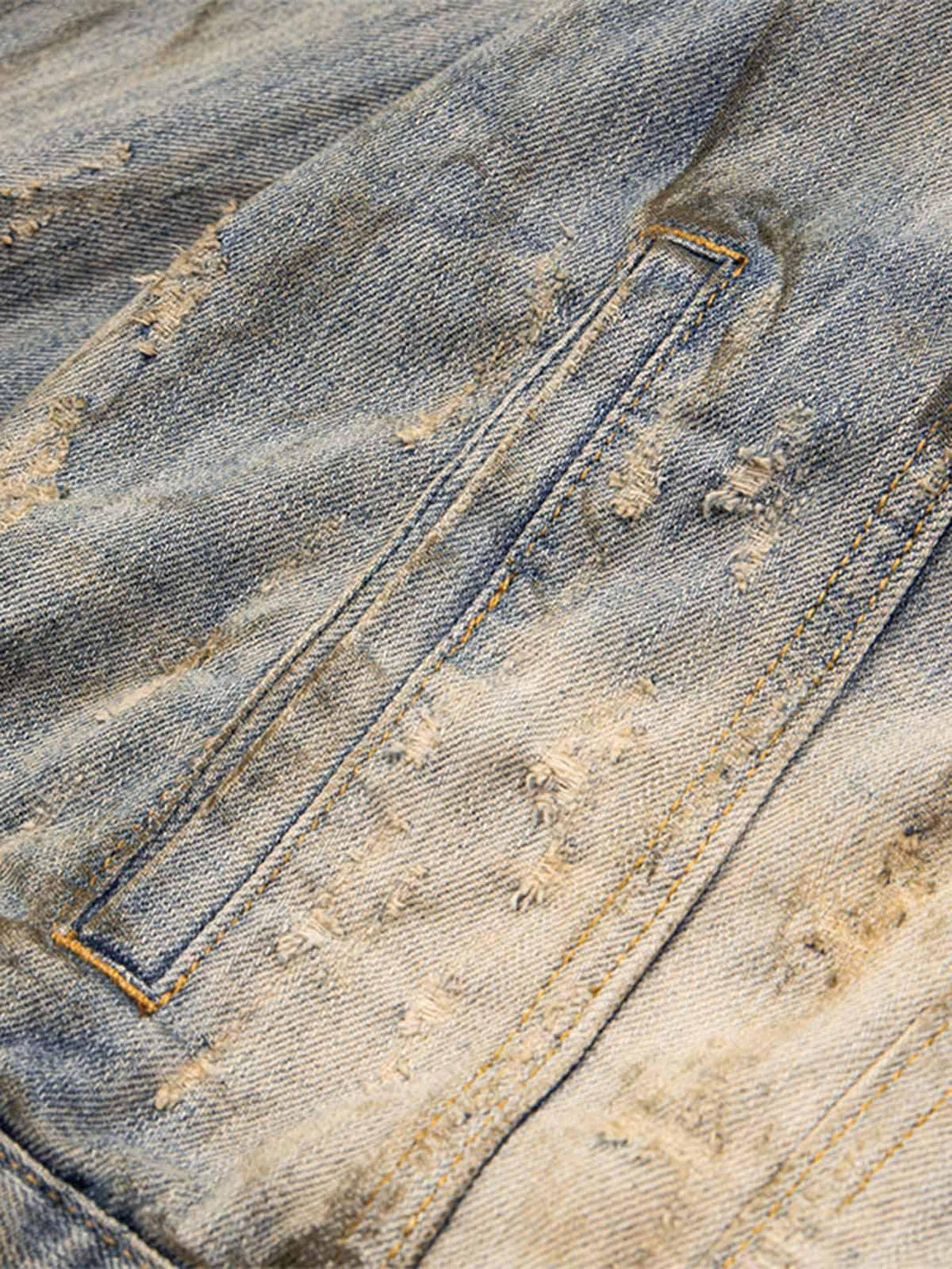 Detailed fabric and stitching of mud-dyed distressed denim by TALISHKO.