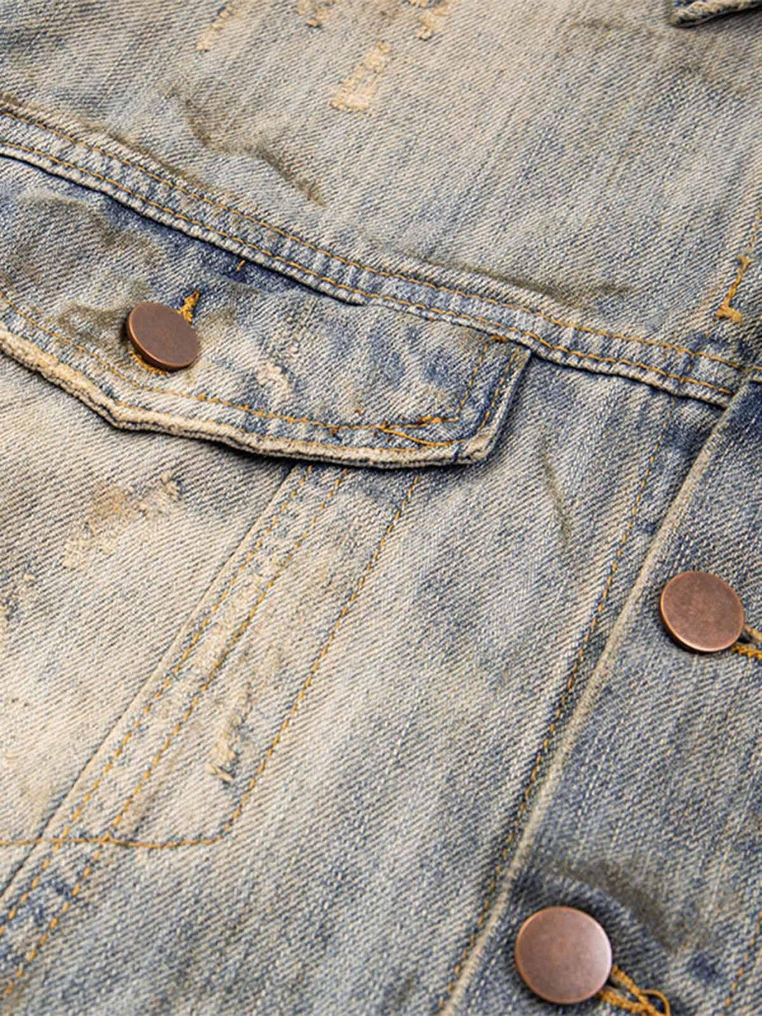 Focusing on the mud-dyed distressed denim texture and copper button details by TALISHKO.