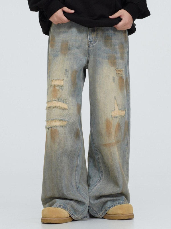 TALISHKO distressed jeans with a vintage fade, featuring a relaxed fit and unique mud dyeing.