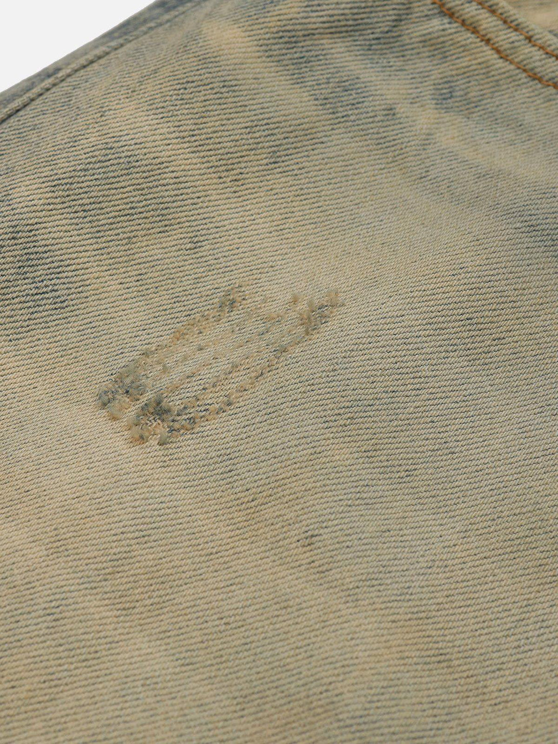 Intricate look at TALISHKO mud dyeing jeans, highlighting unique texture and stitching detail.