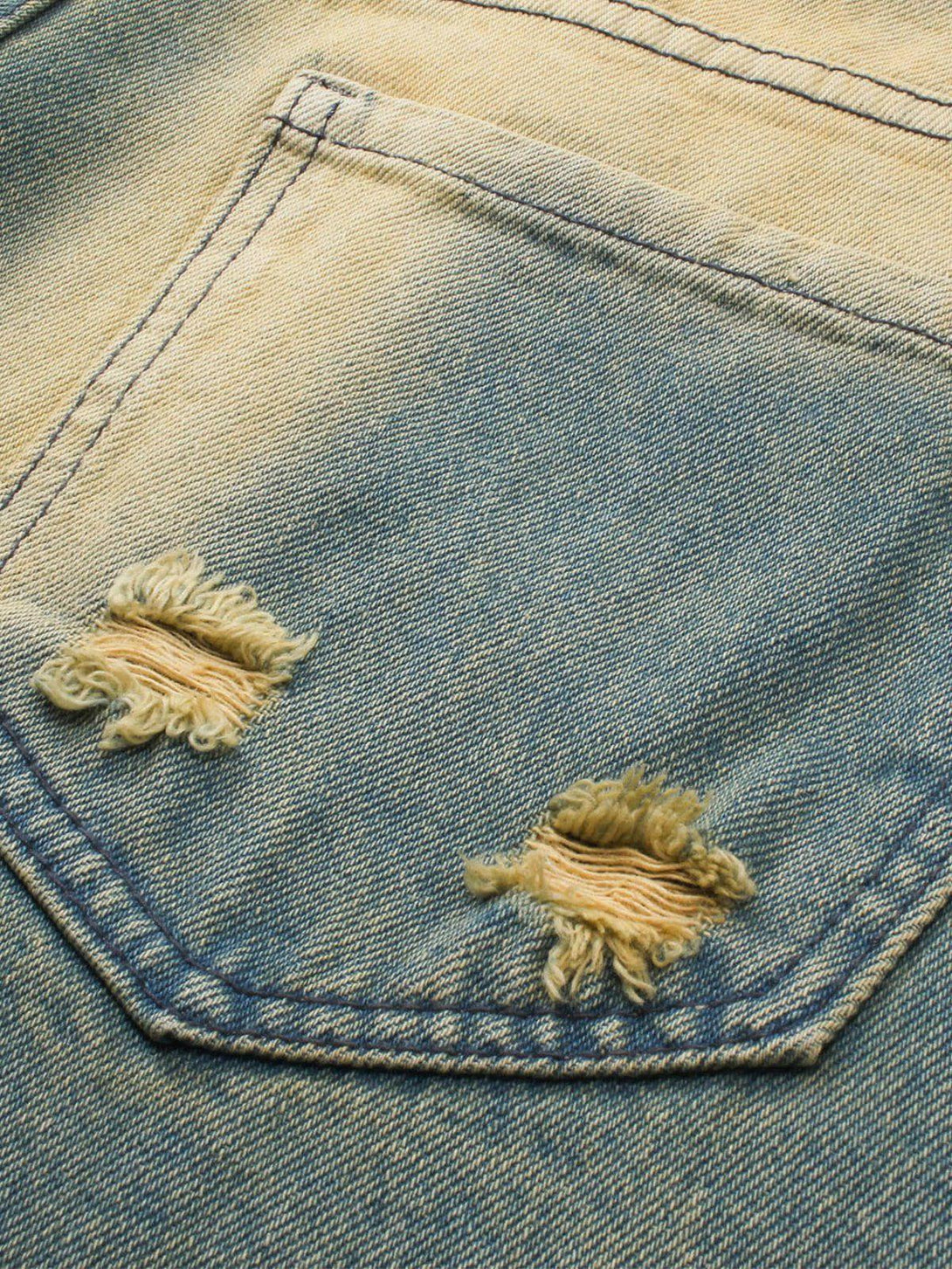 Detailed fabric and distressed pocket design on TALISHKO's mud-dyed loose jeans.