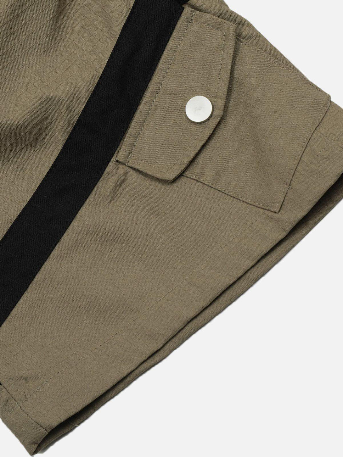 A detailed view of TALISHKO cargo pants showcasing the buttoned pocket and black accent strip.