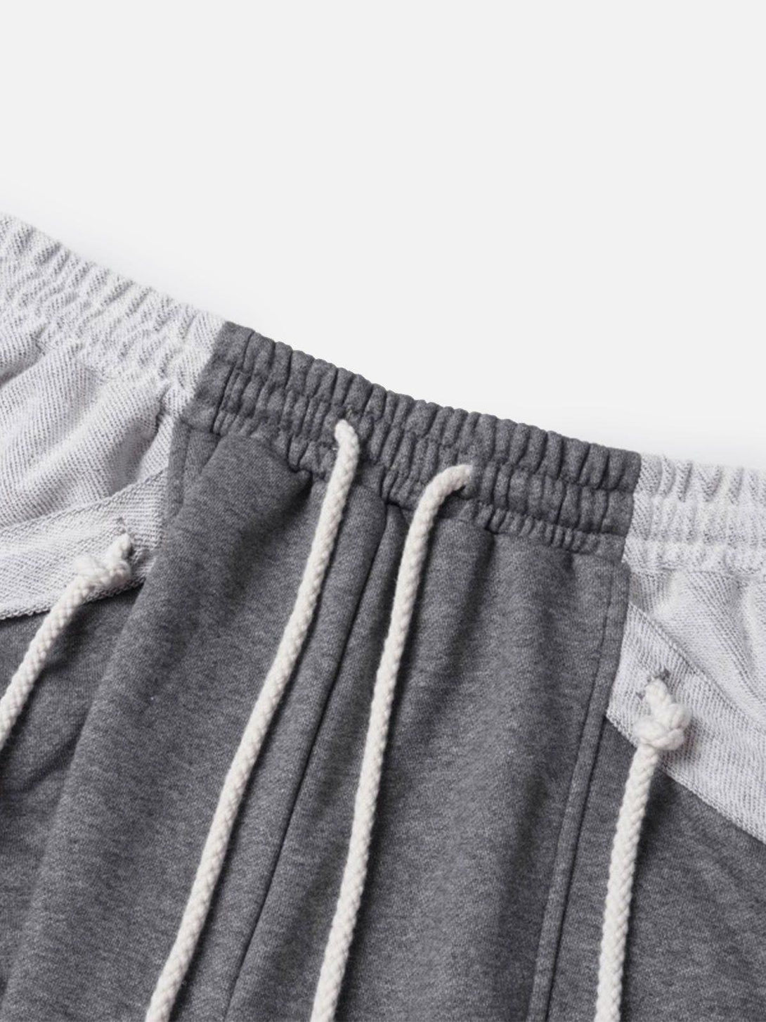 A close-up of TALISHKO's gray multi drawstring shorts, highlighting the elastic waistband and ties.