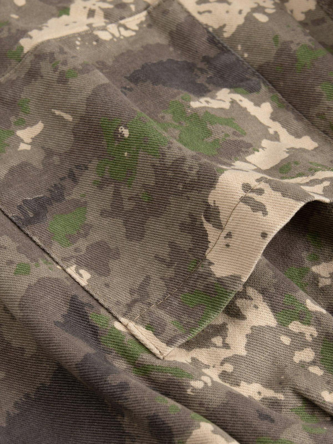 Zoomed-in texture of TALISHKO camouflage shorts showcasing detailed fabric and stitching.