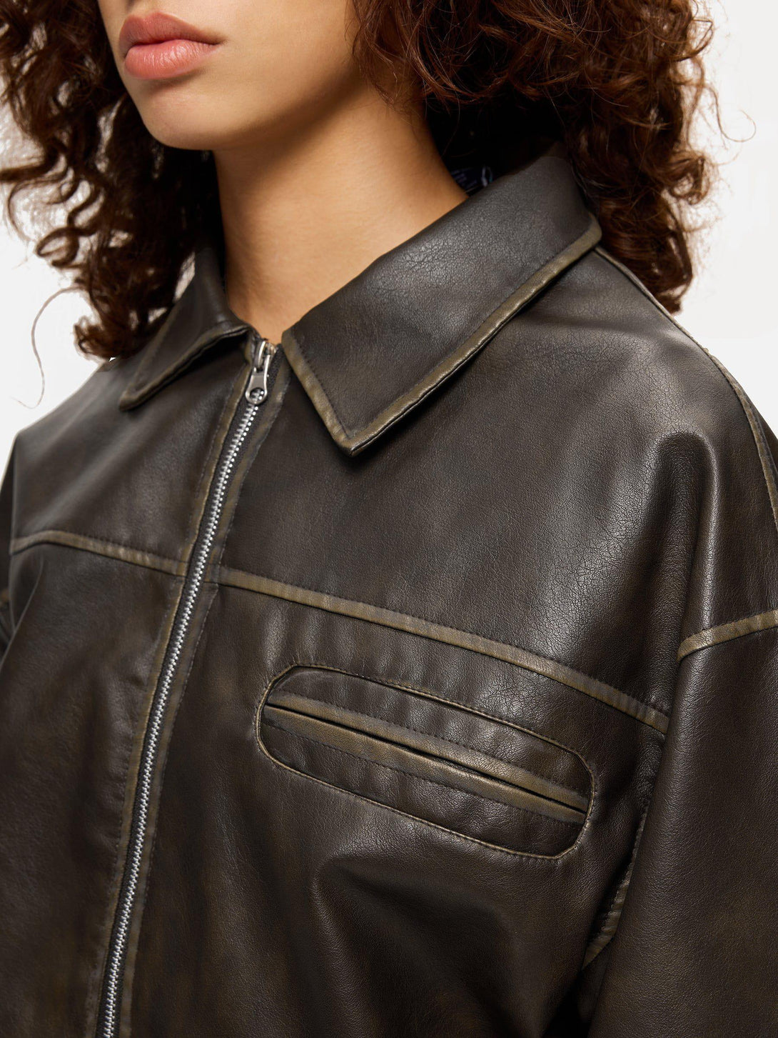 A close-up of the TALISHKO faux leather jacket, highlighting its multi-pocket detail and texture.