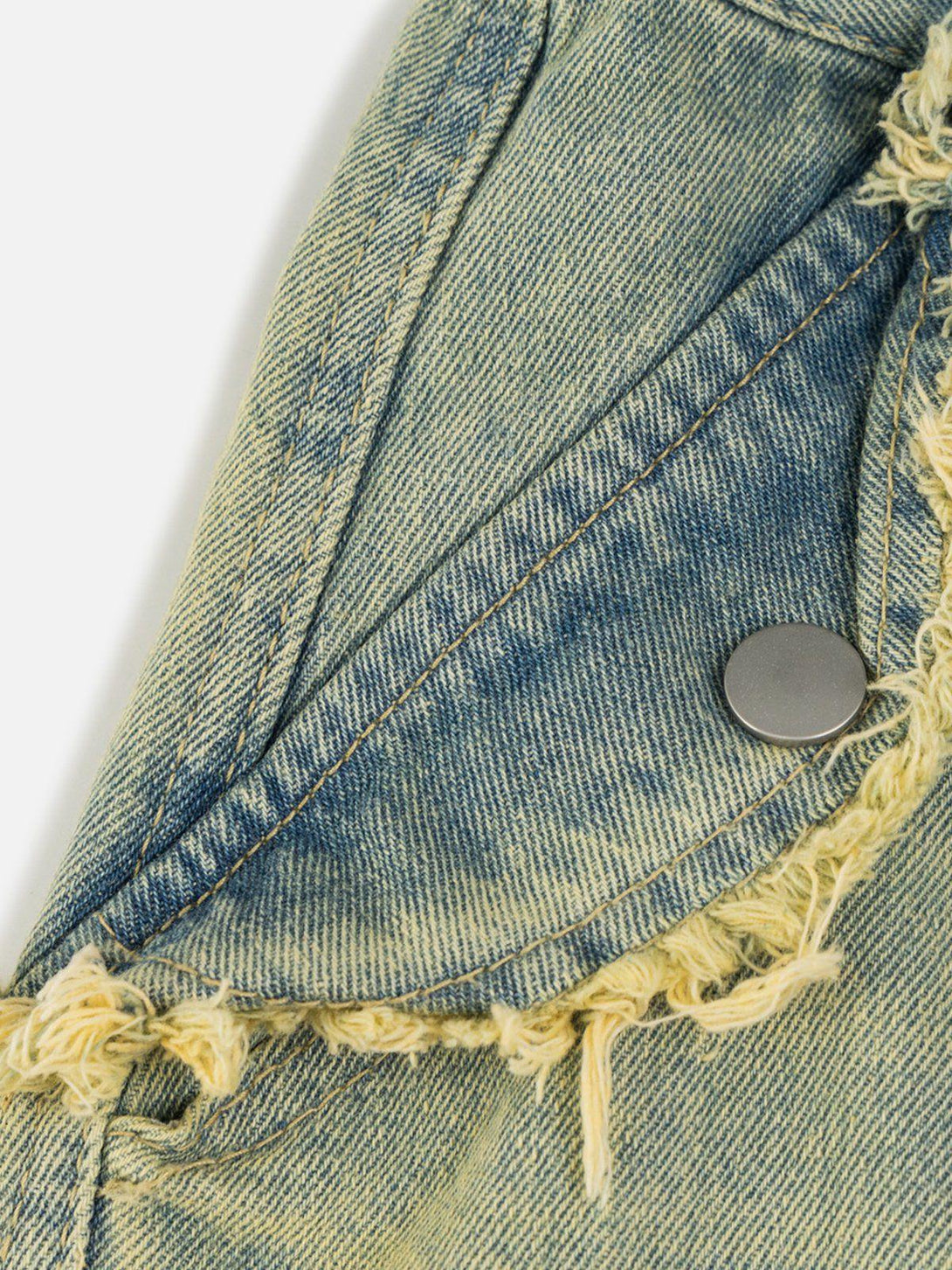 A detailed view of TALISHKO's multi-pocket fringe washed jeans, highlighting the distressed texture.