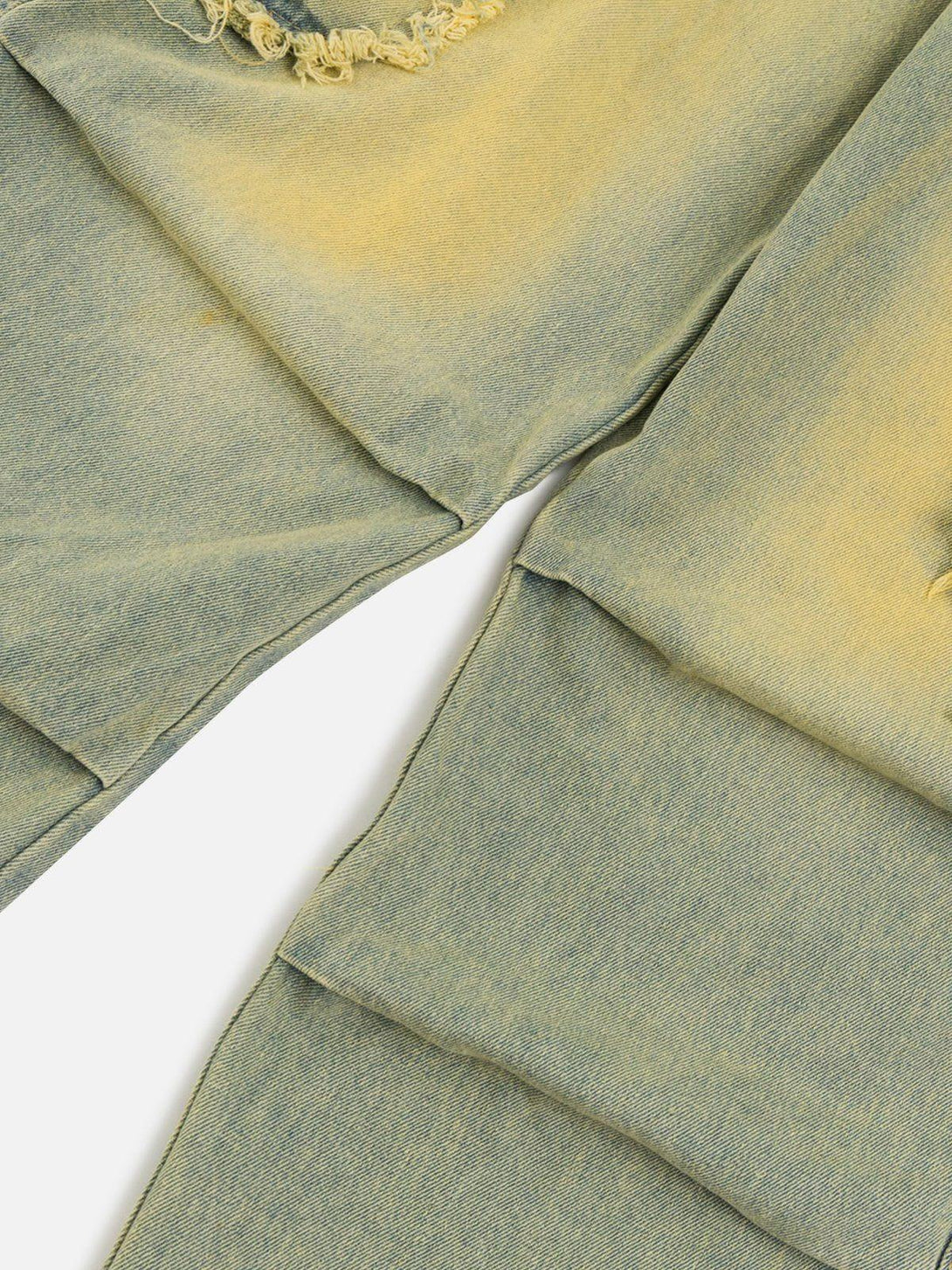 Focusing on the distressed fabric of TALISHKO's multi-pocket fringe washed jeans, showcasing vintage flair.