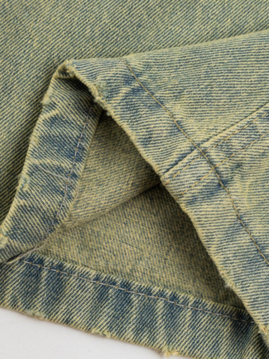 Intricate look at TALISHKO's multi-pocket fringe washed jeans, showcasing unique stitching.
