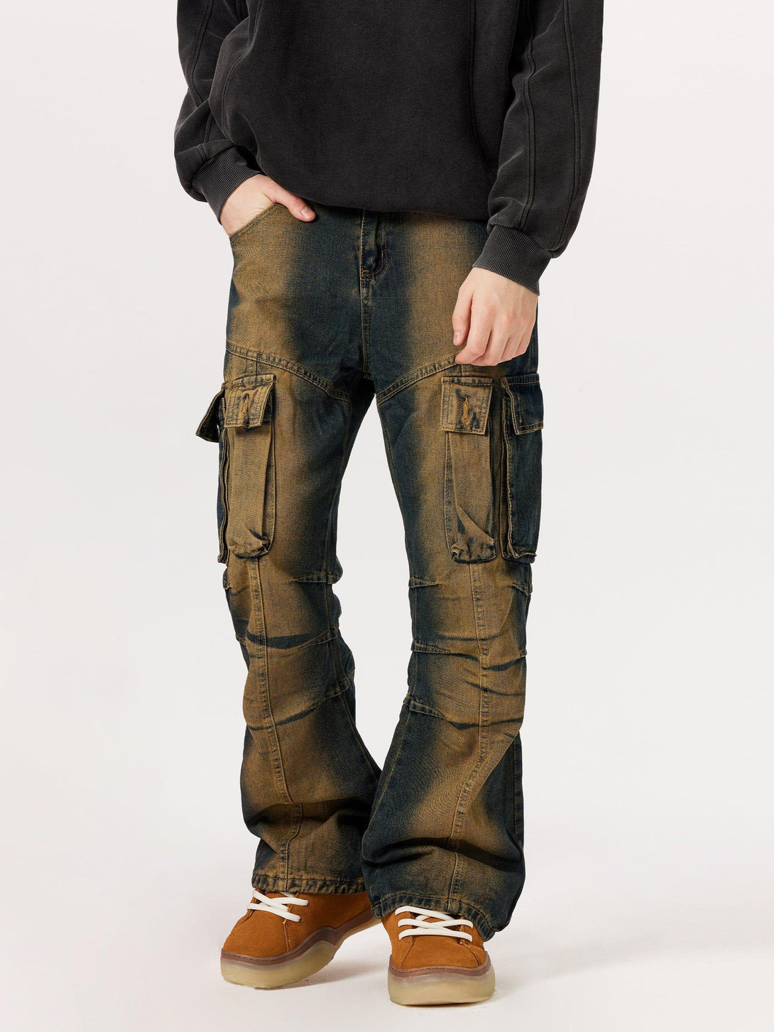 Model wearing multi-pocket washed cargo jeans by TALISHKO, paired with casual sneakers.