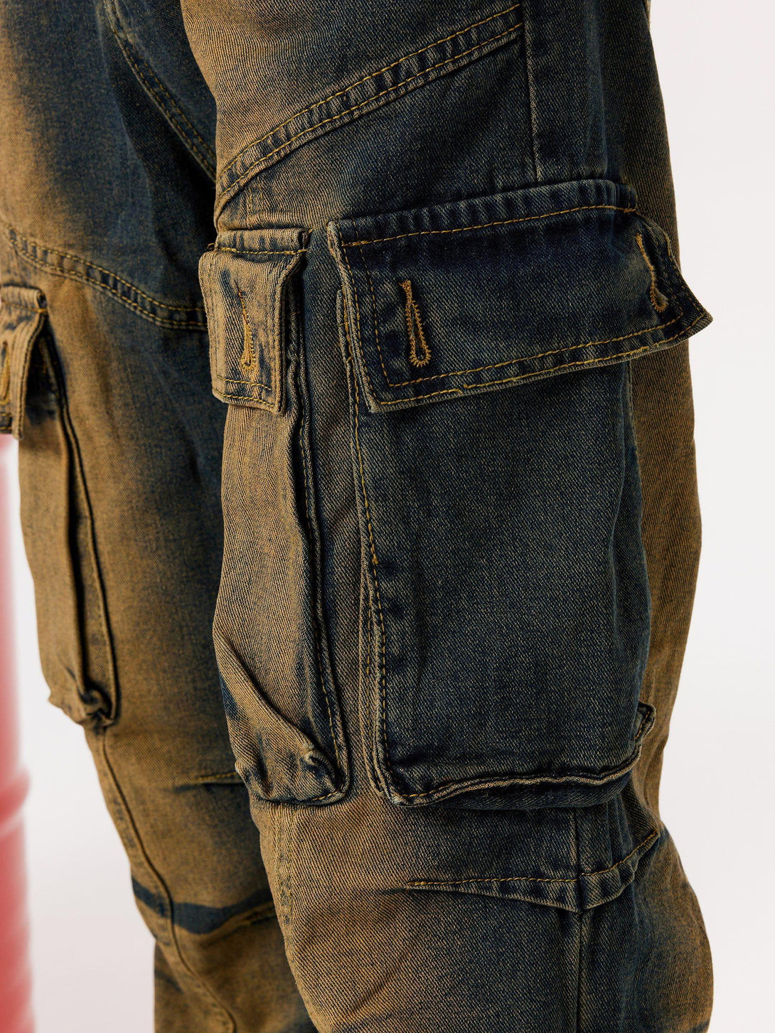 Detailed view of TALISHKO cargo jeans, showcasing multi-pocket design and washed fabric texture.