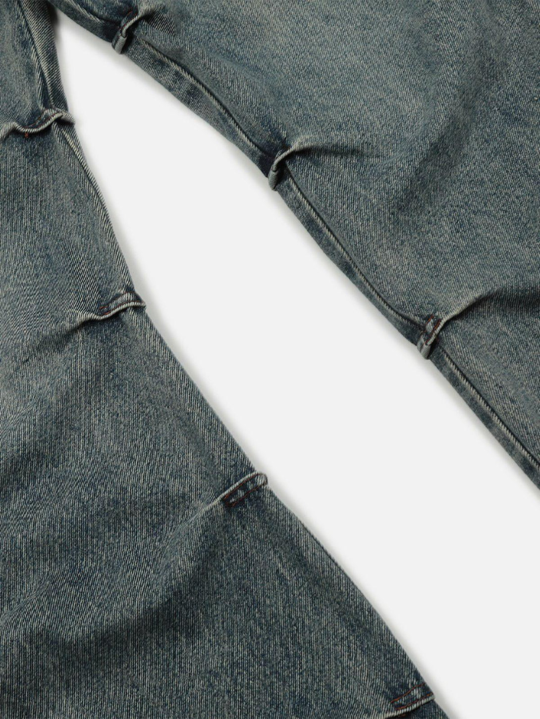 Intricate look at TALISHKO wrinkle-washed jeans, highlighting unique seam and texture details.