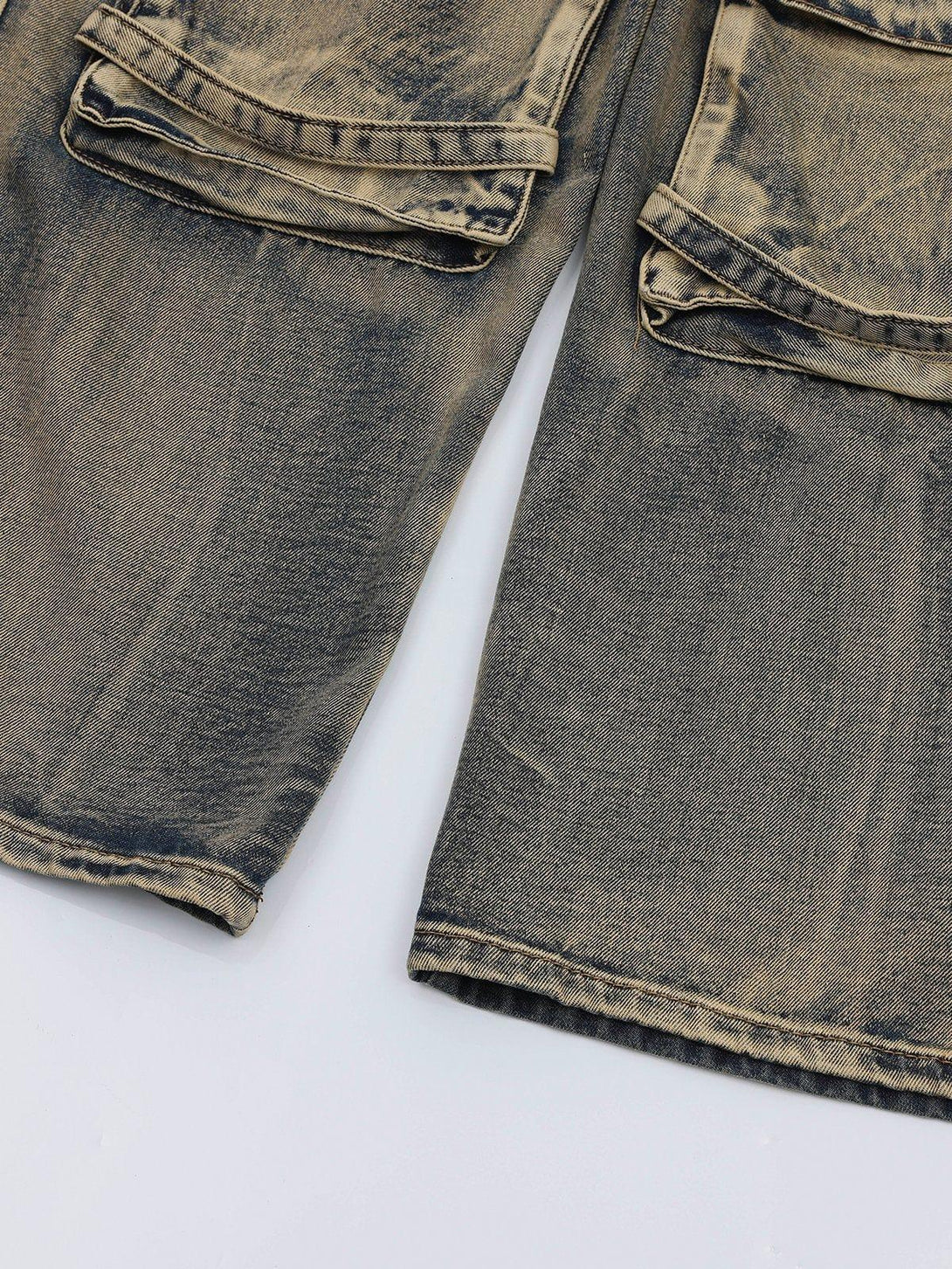 A close-up of TALISHKO's washed jeans, emphasizing detailed pockets and faded texture.