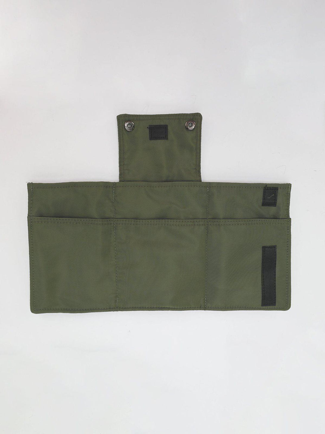 Detailed view of TALISHKO's green multipurpose bag, showcasing interior pockets and snap closures.