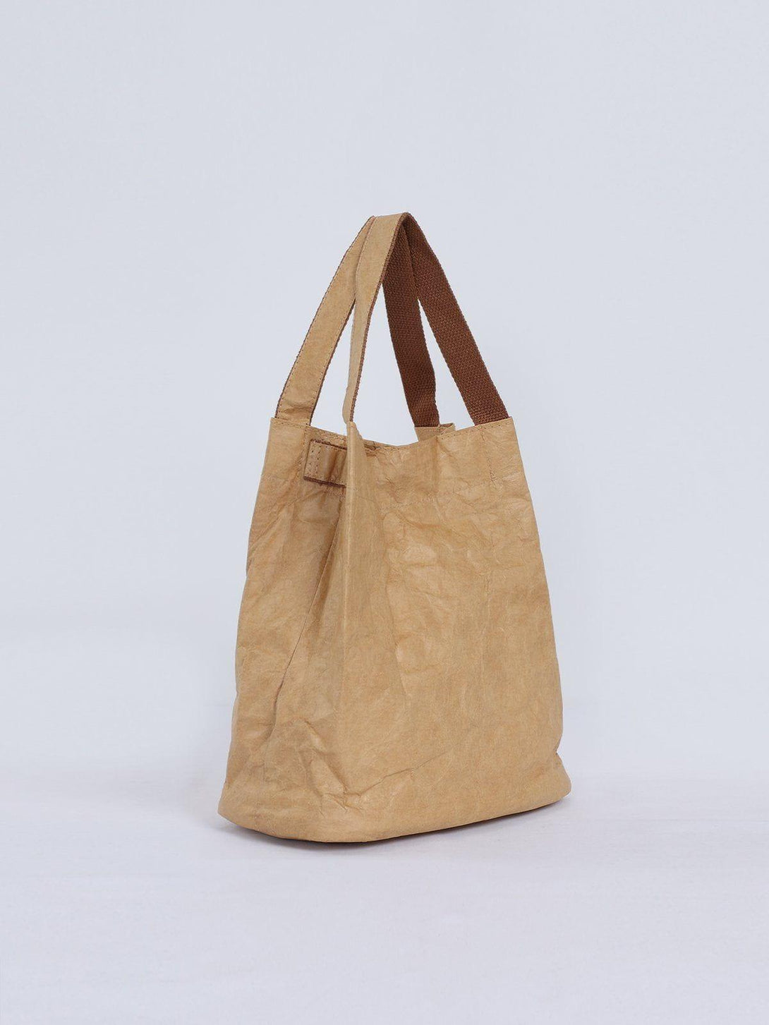 Side view of TALISHKO's natural wrinkle kraft paper bag with brown handles, showcasing its unique texture.