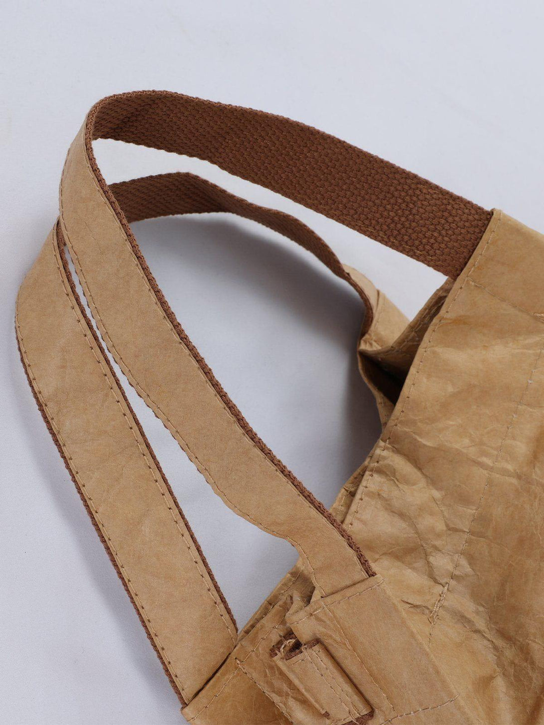 Detailed view of TALISHKO's natural wrinkle kraft paper bag, highlighting brown handle texture.