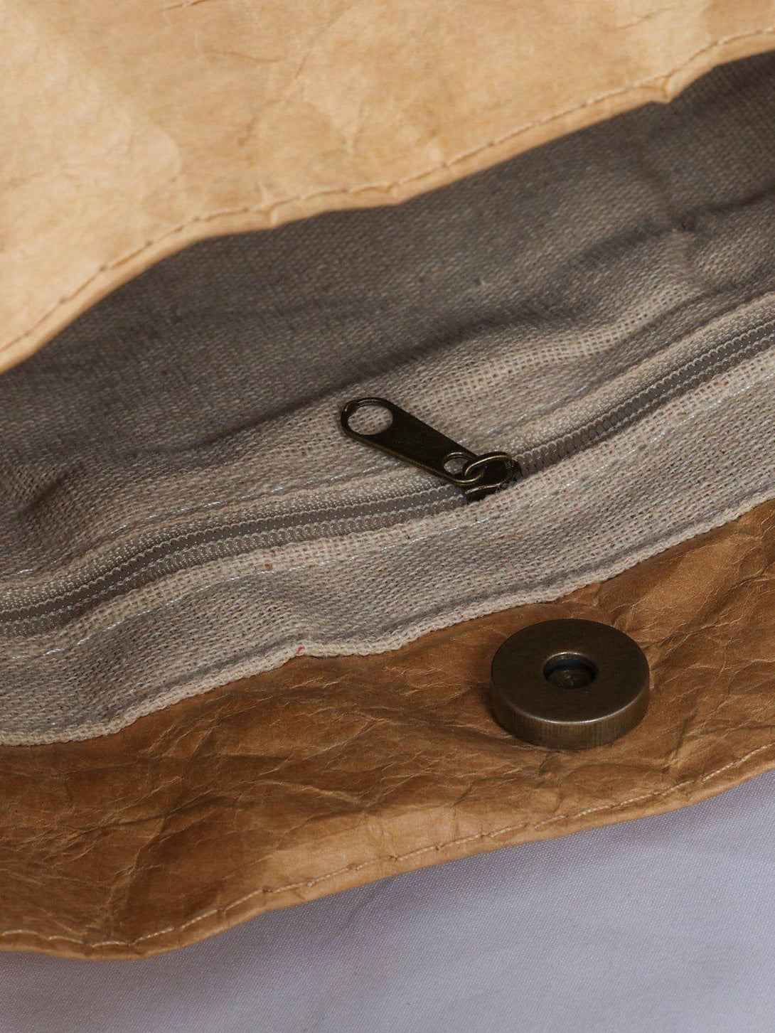 Detailed view of TALISHKO's natural wrinkle kraft paper bag, highlighting zipper and button details.