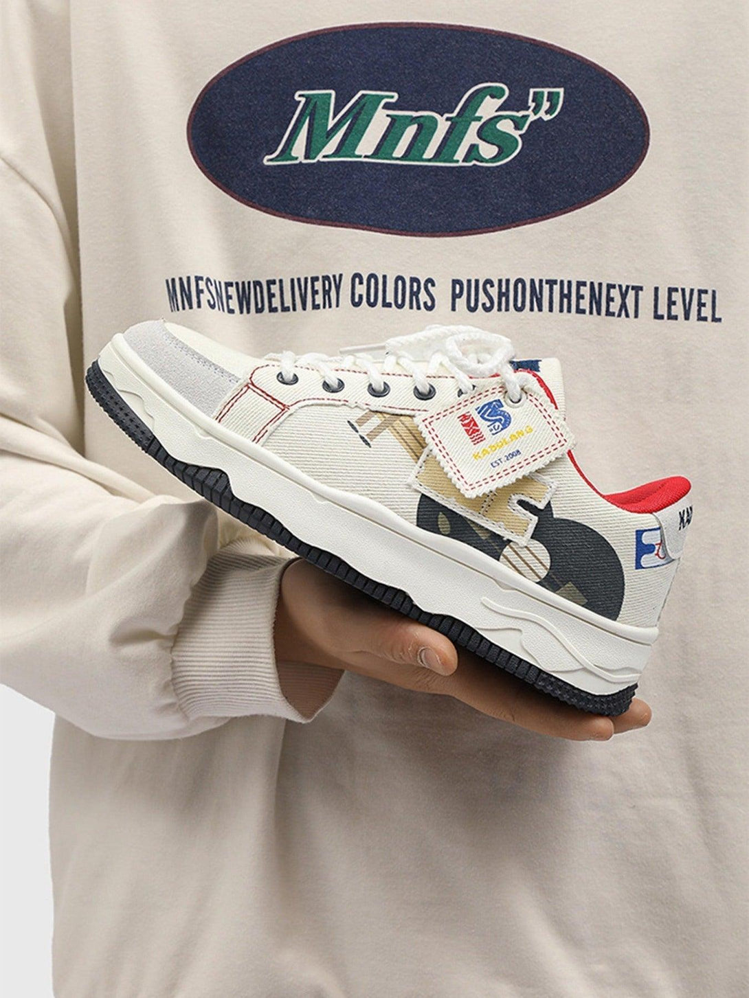 TALISHKO canvas shoes with graphic details, held in hand, showcasing modern casual style.