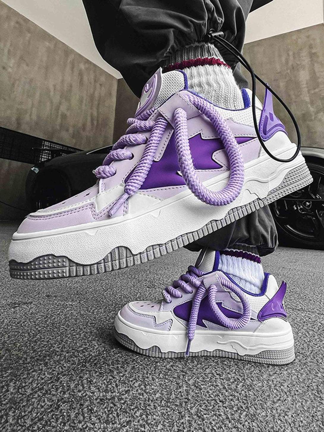 Stylish TALISHKO retro board shoes in purple, worn with joggers, highlighting bold design.