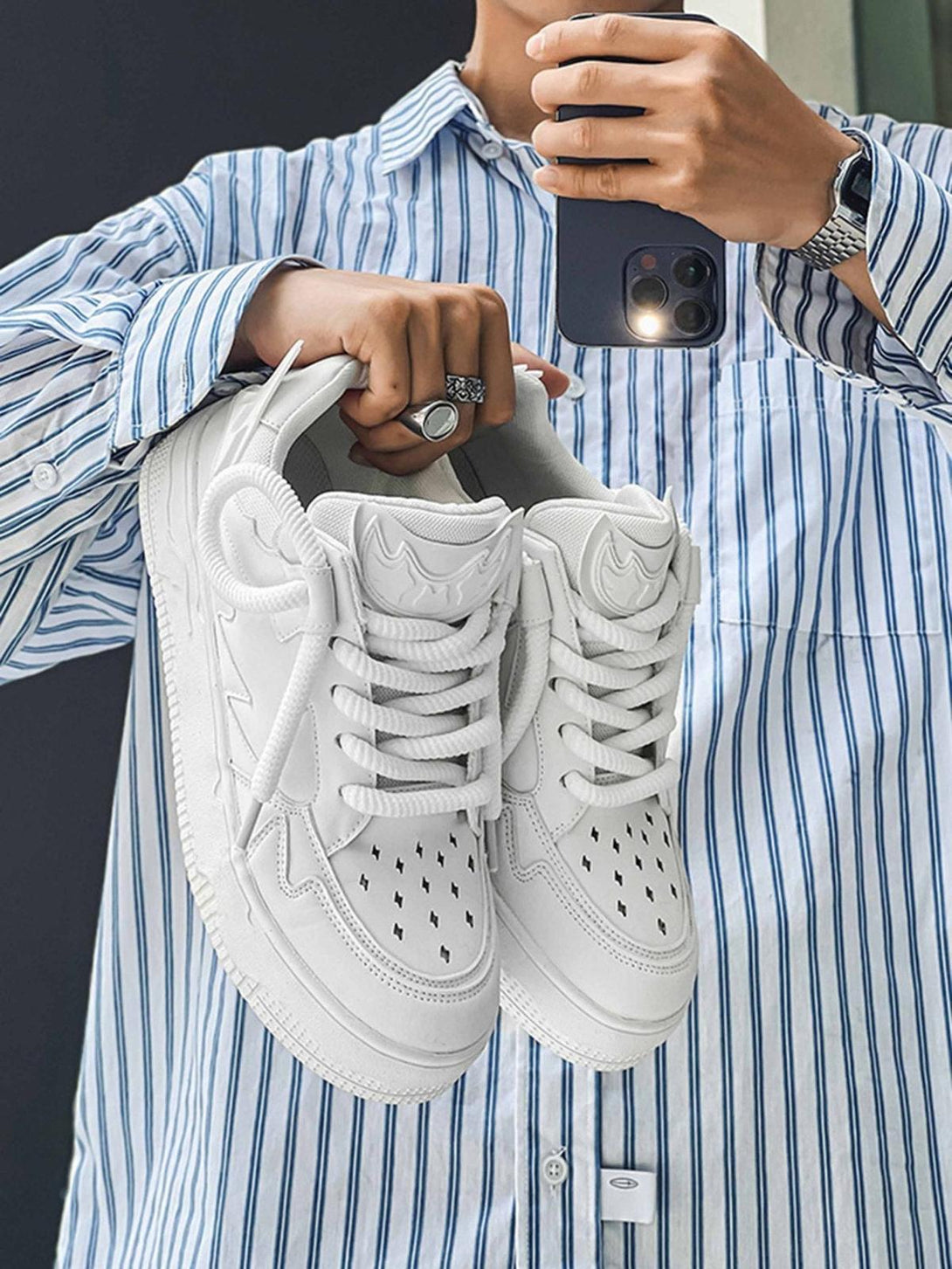 TALISHKO retro board shoes in white, held casually, highlighting stylish perforated details.