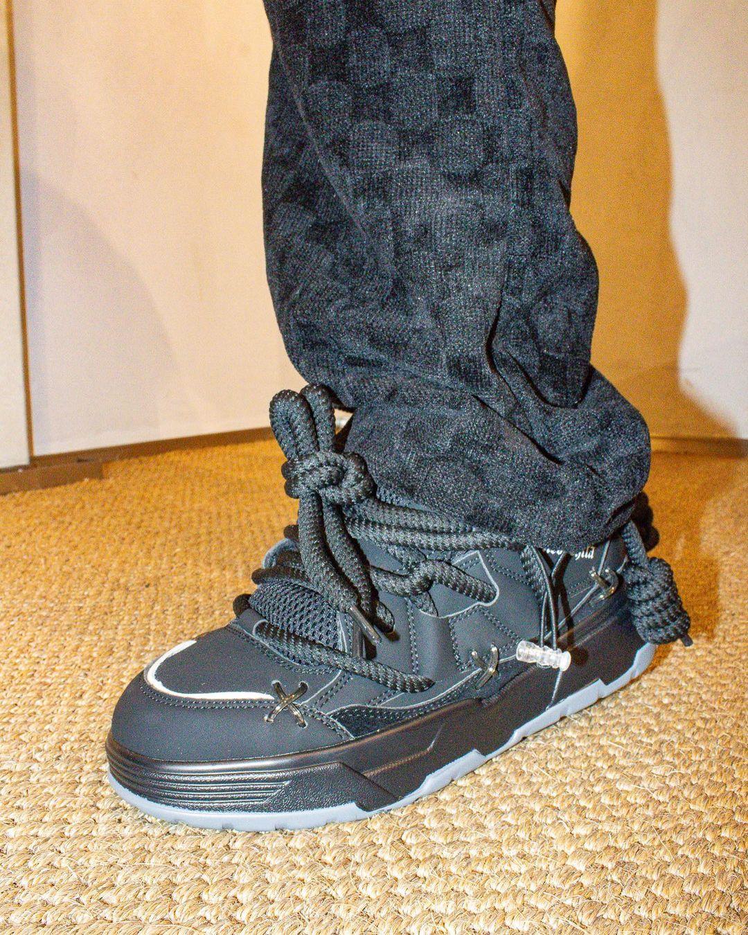 Model wearing TALISHKO thick-soled board shoes with unique laces, paired with black pants.