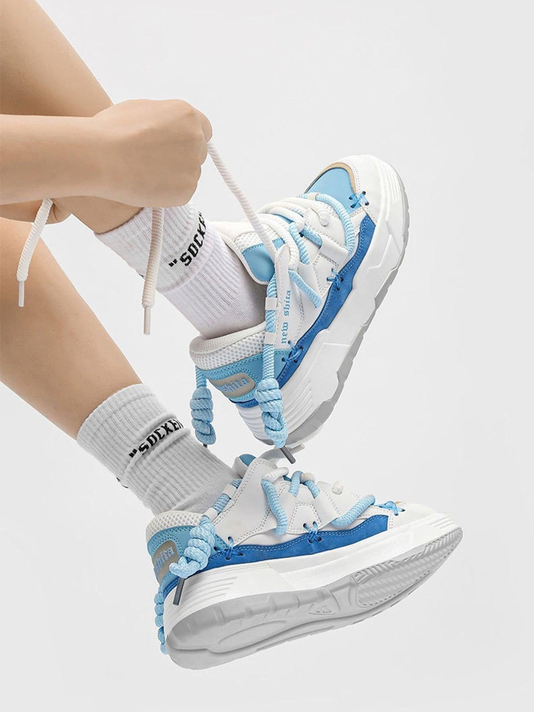 Sporty blue and white board shoes by TALISHKO, featuring thick soles and bold laces.