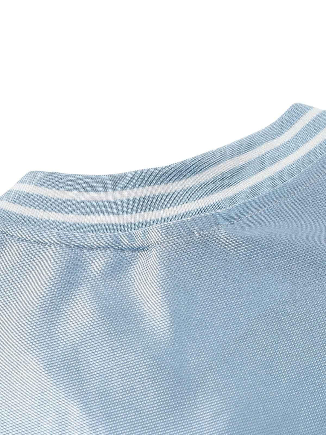 A close-up of TALISHKO's light blue jersey T-shirt, highlighting the striped neckline detail.