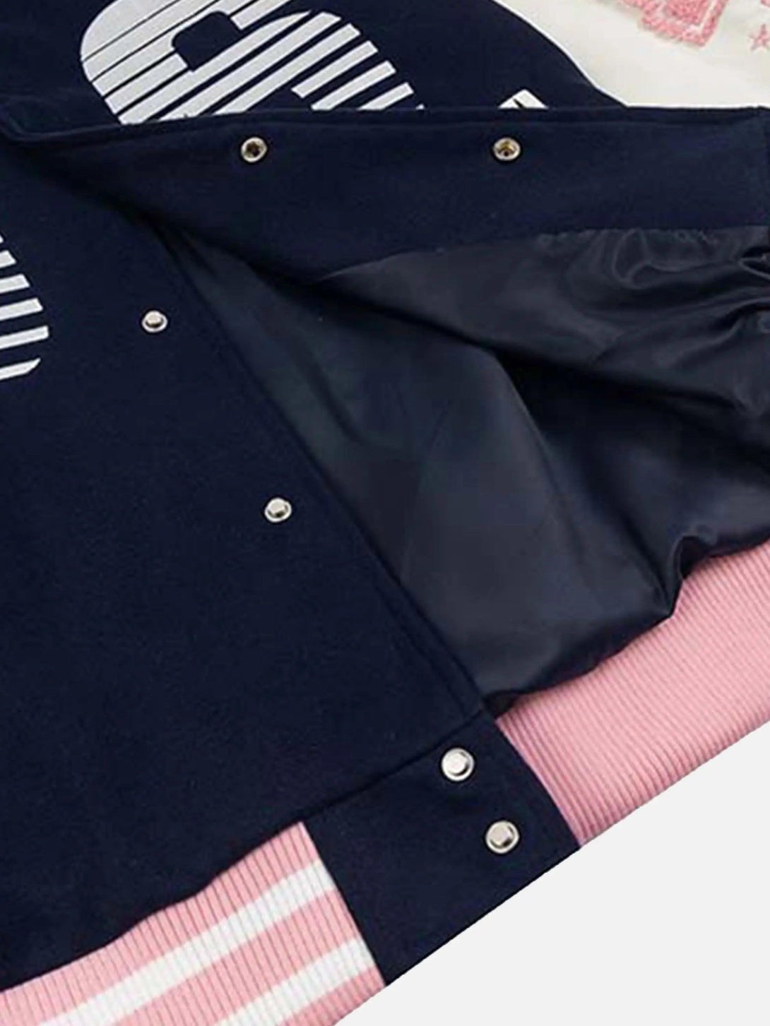 A tight crop highlighting the inner lining and snap closures of a TALISHKO baseball jacket.