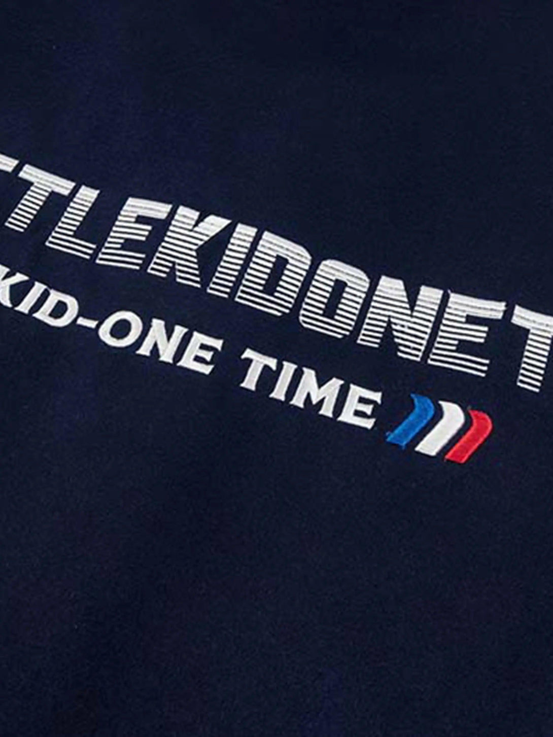 Zoomed-in texture of a TALISHKO baseball jacket, highlighting embroidered text and vibrant colors.
