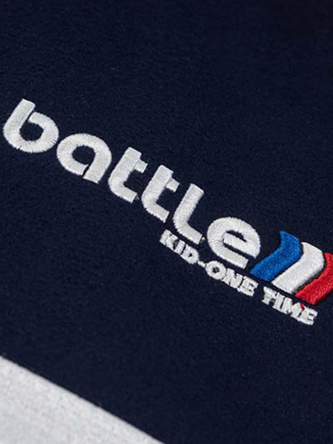 Detailed fabric and stitching of a TALISHKO baseball jacket, showcasing embroidered text.