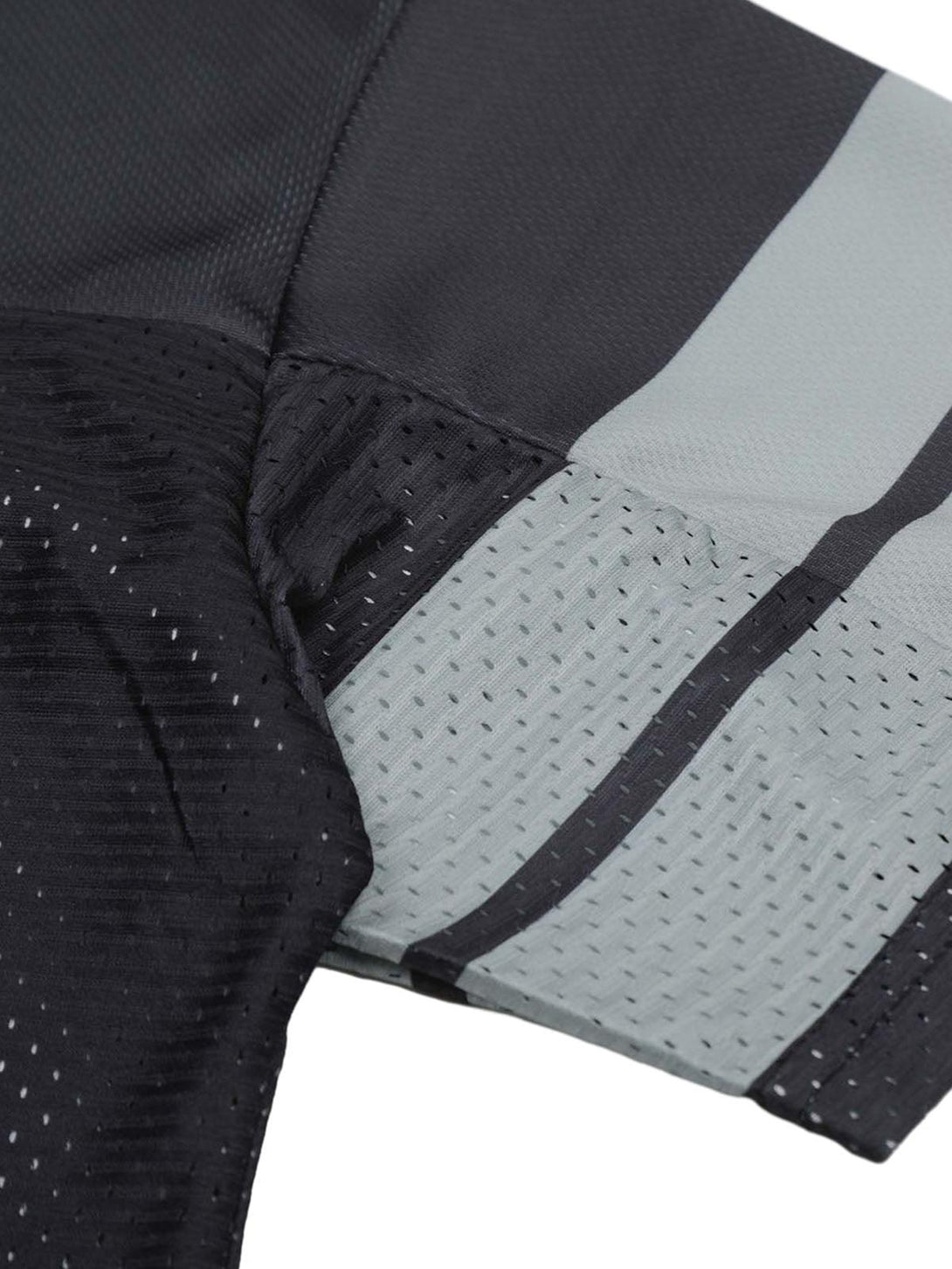 Focusing on the textured sleeve design of a TALISHKO sports jersey T-shirt in dark tones.