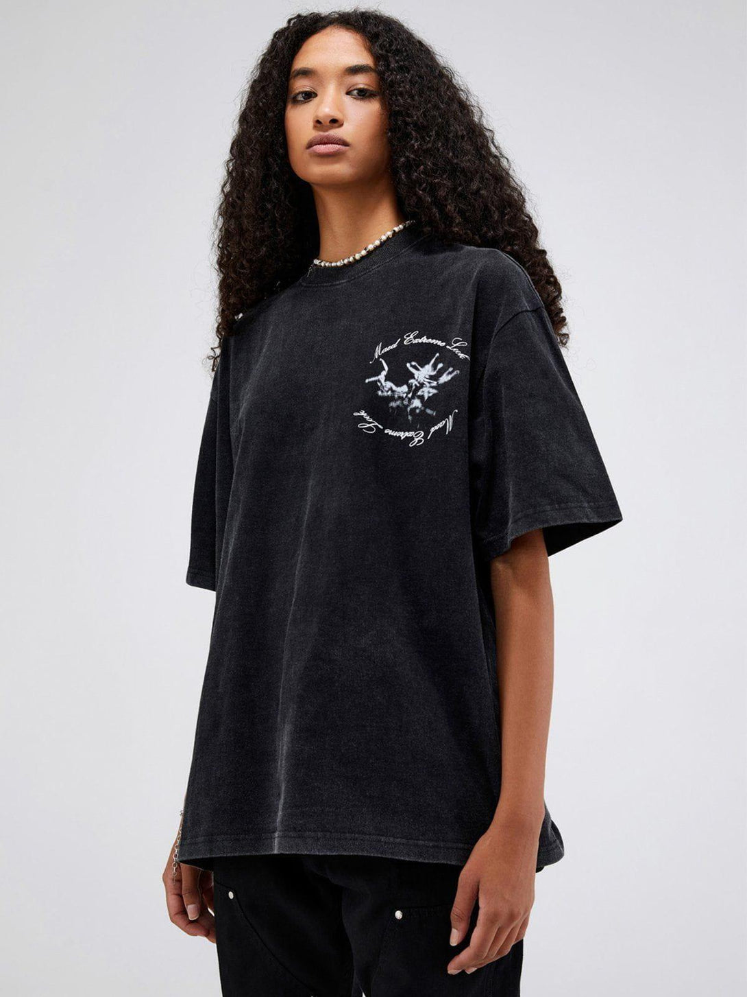 Model wearing a TALISHKO black graphic tee with an obscure monster design on the front.