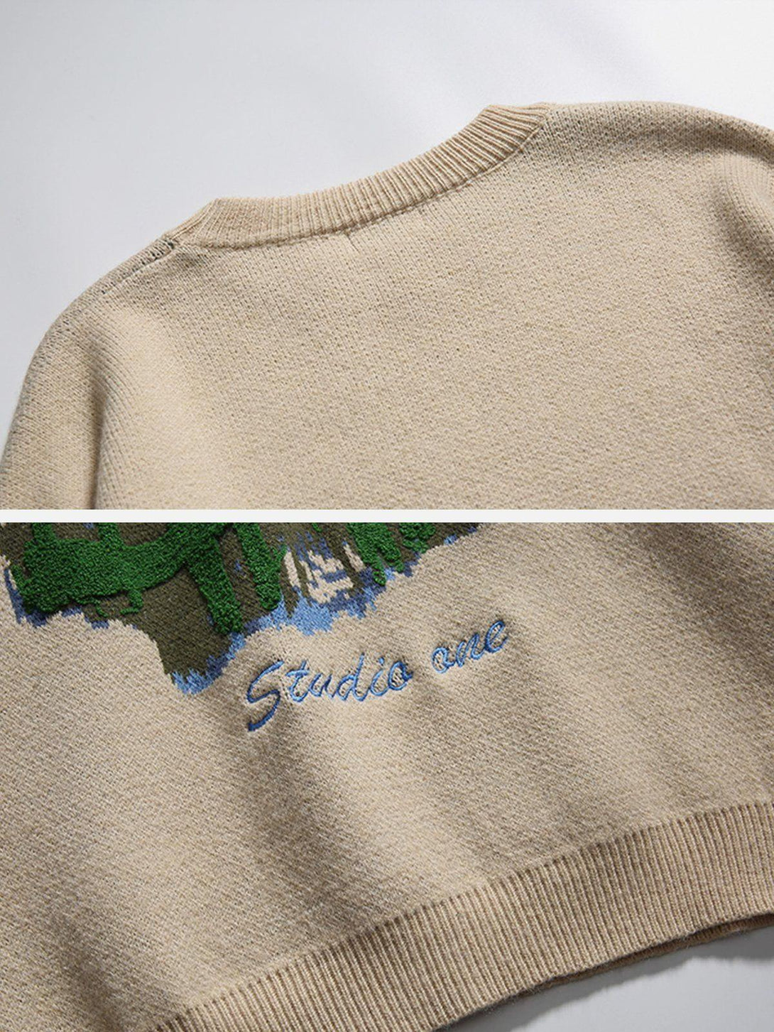 A detailed view of the TALISHKO sweater's knit texture and embroidered mountain design.