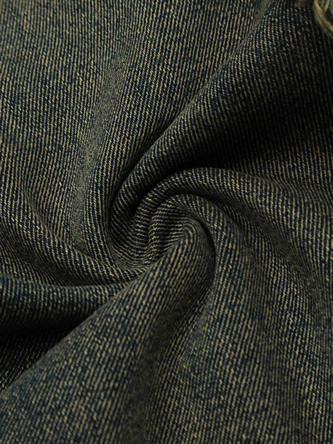 Intricate look at TALISHKO jeans' texture, showcasing durable fabric and raw hem details.
