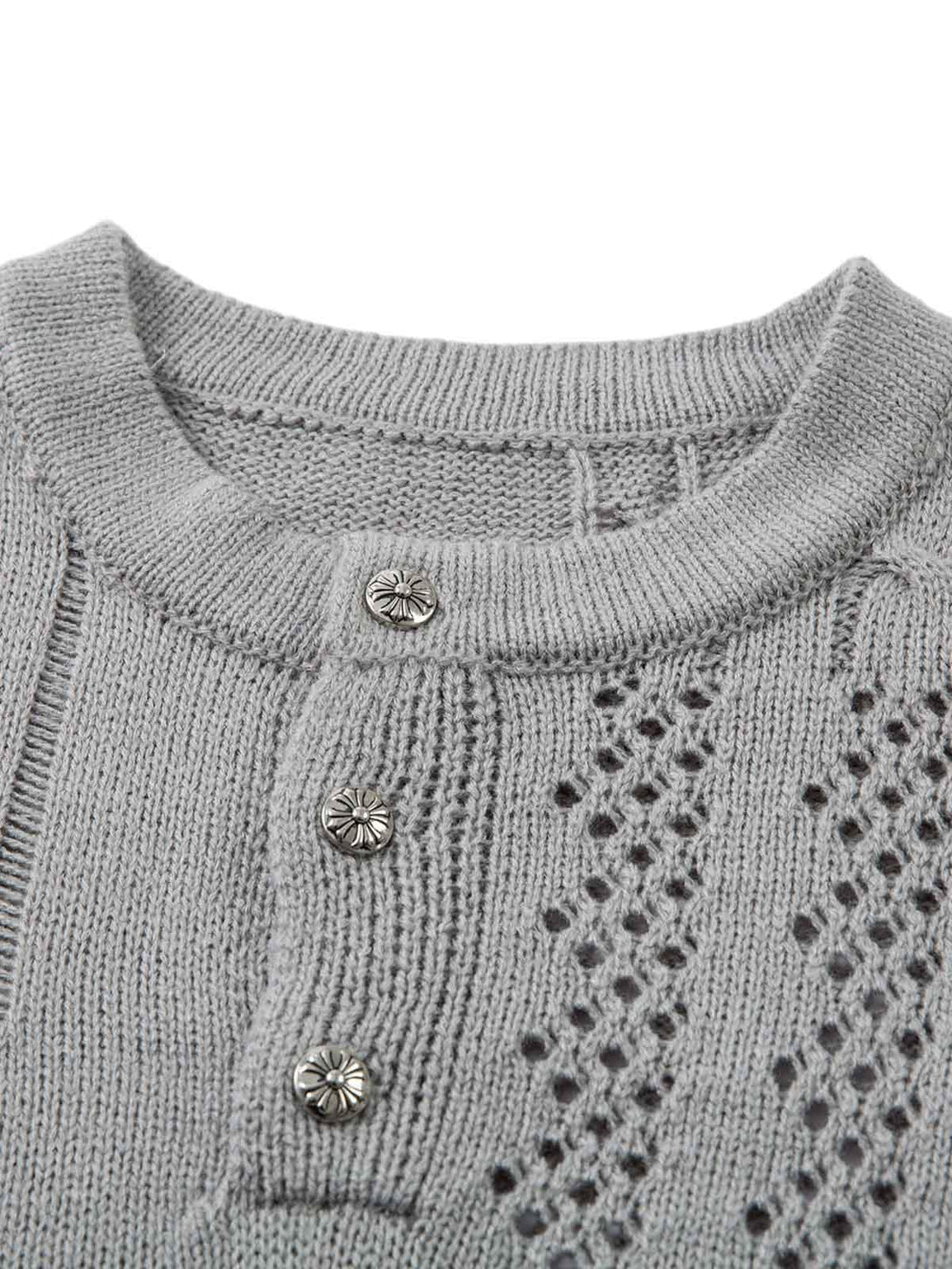 A detailed view of the TALISHKO openwork knit sweater, highlighting intricate button and pattern design.