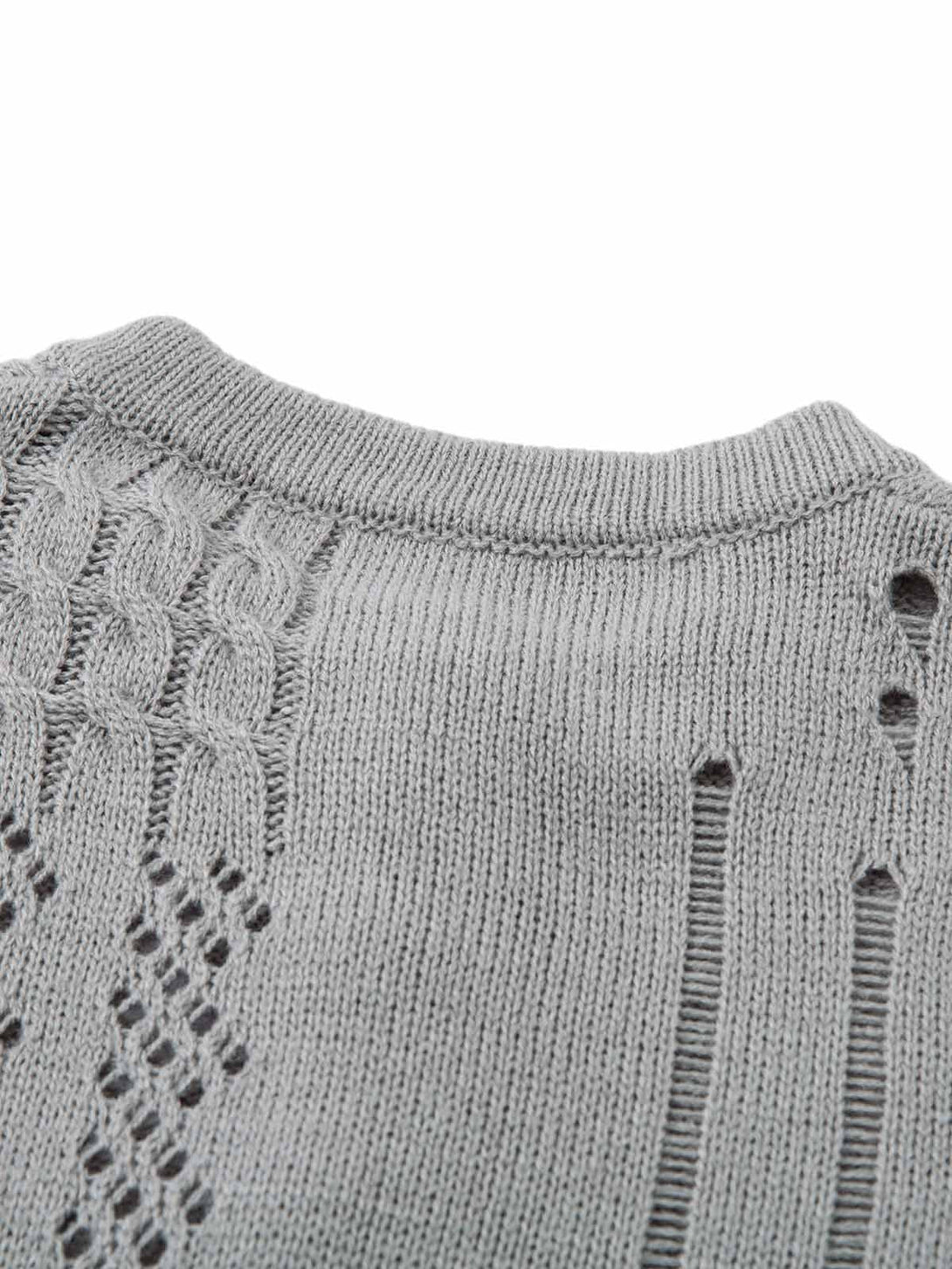 Texture and pattern showcased in a gray openwork knit sweater detail by TALISHKO.