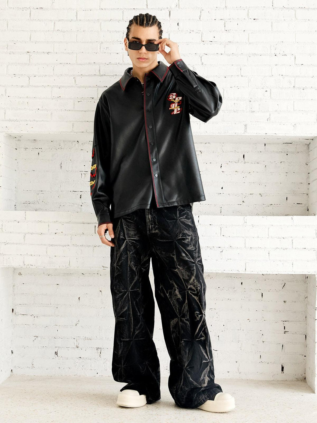 Model in TALISHKO's stylish leather shirt with striking embroidery, paired with oversized pants.