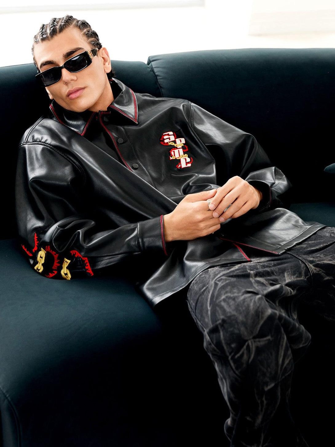 Model lounging in TALISHKO's embroidered leather shirt, combining edgy flair with street style.