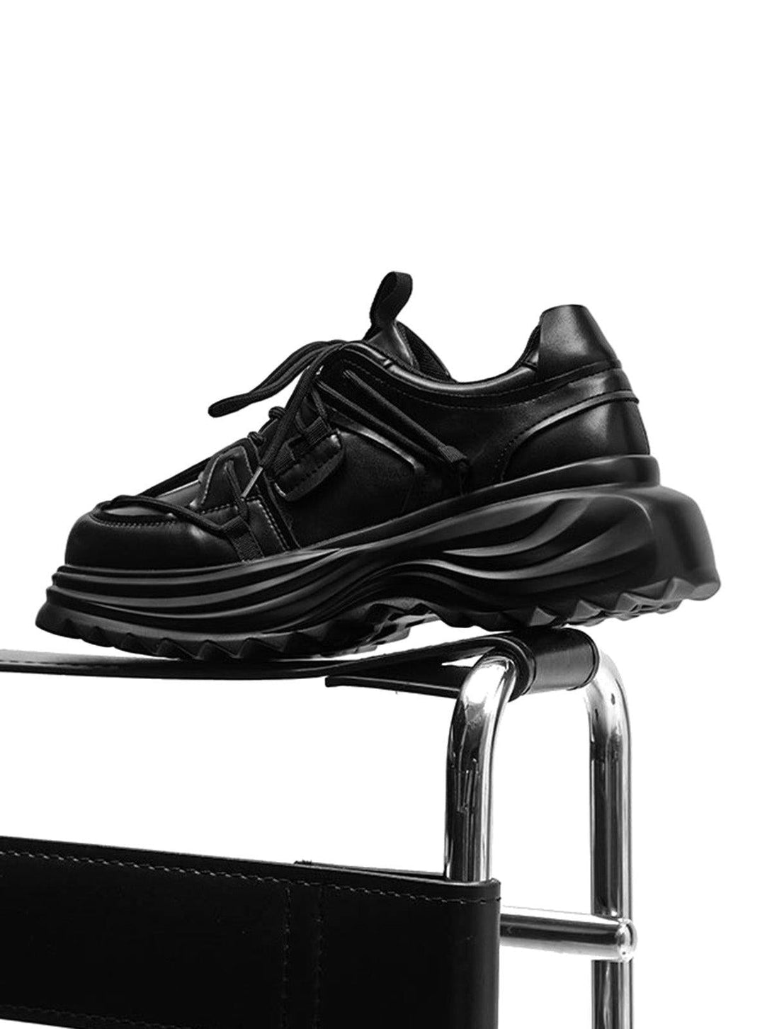 TALISHKO black platform sneakers on a chair, side view highlighting bold outdoor workwear style.