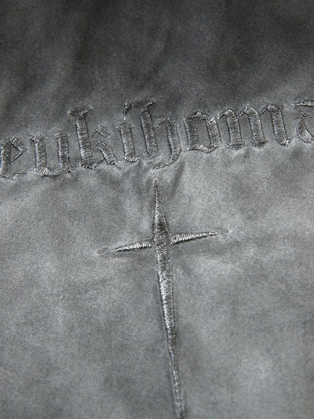 Intricate embroidery detail on TALISHKO oversized t-shirt, highlighting cross design.