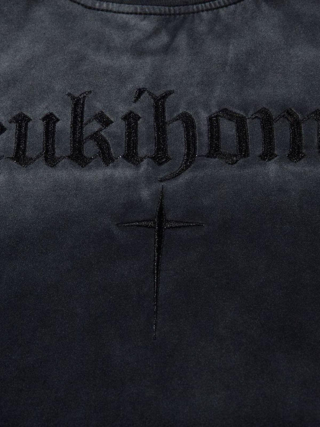 Detailed embroidery on TALISHKO t-shirt, featuring cross design and bold lettering.