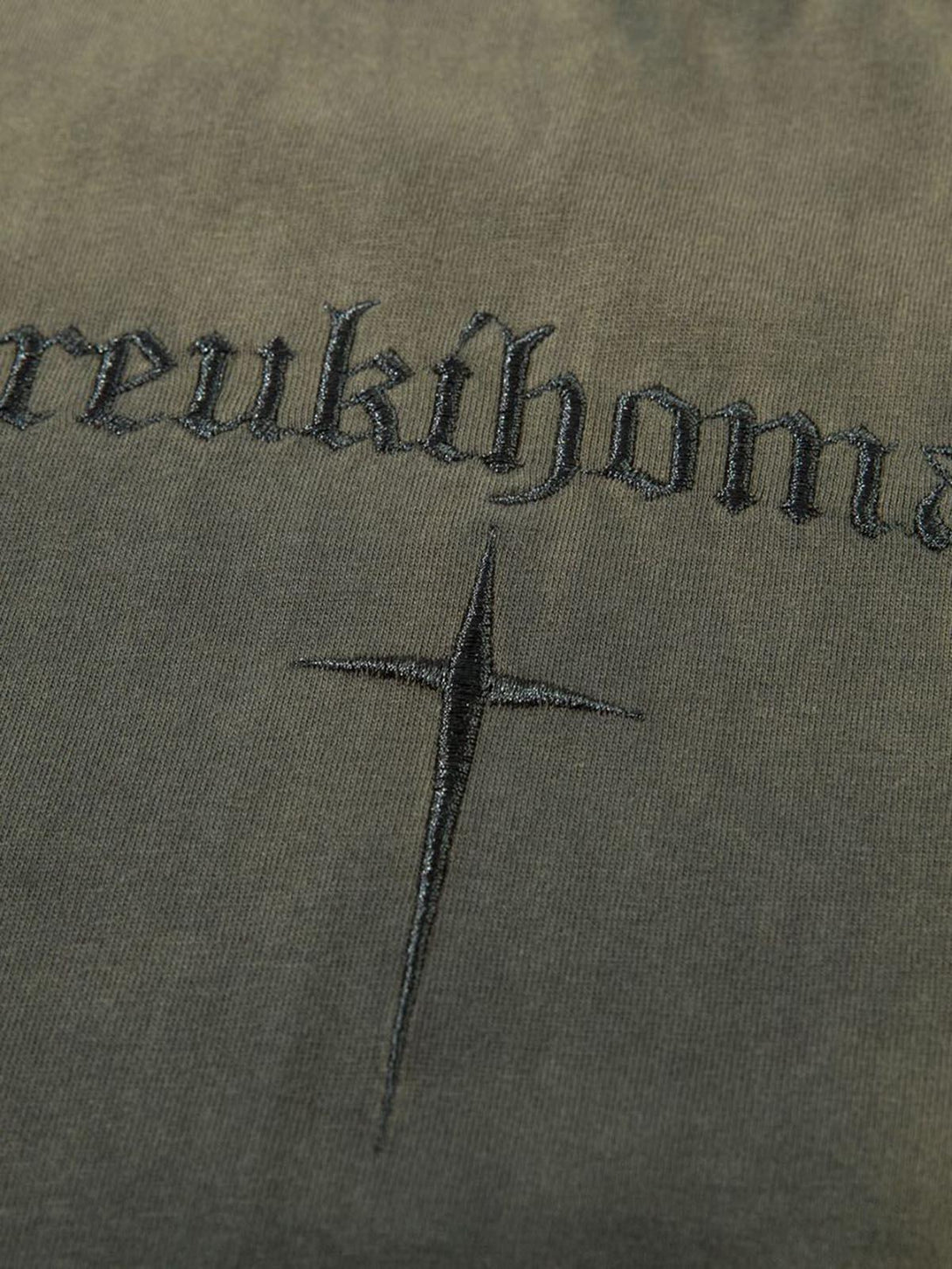 Intricate look at TALISHKO t-shirt with bold lettering and cross embroidery detail.