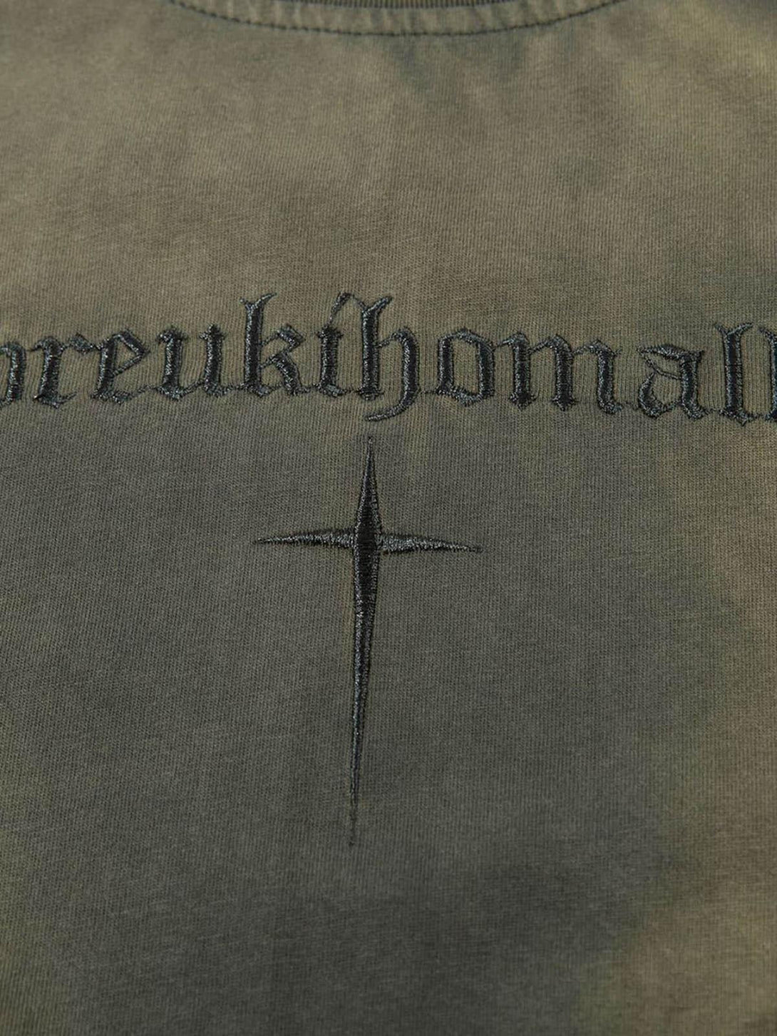 Detailed look at TALISHKO t-shirt highlighting intricate embroidery and cross design.