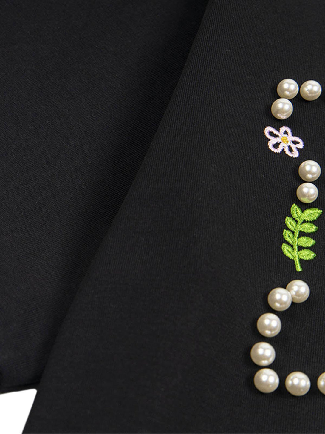 Intricate floral embroidery with pearl accents on a black t-shirt by TALISHKO.
