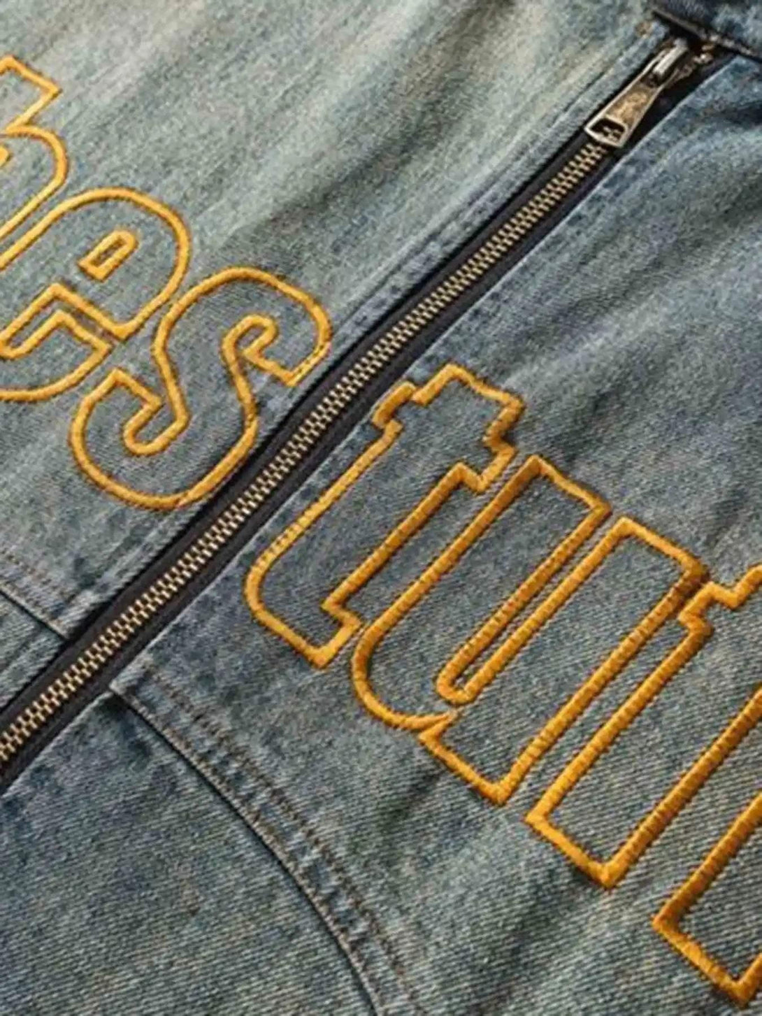 Zoomed-in texture of TALISHKO's embroidered denim jacket, showcasing hip-hop style details.