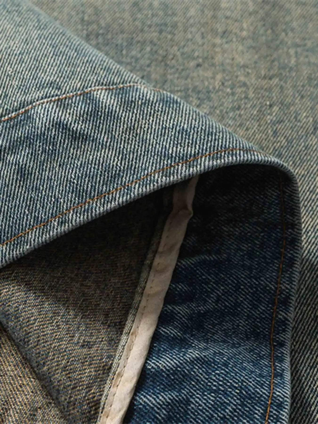 Detailed fabric and stitching on TALISHKO's oversized hip-hop denim jacket.