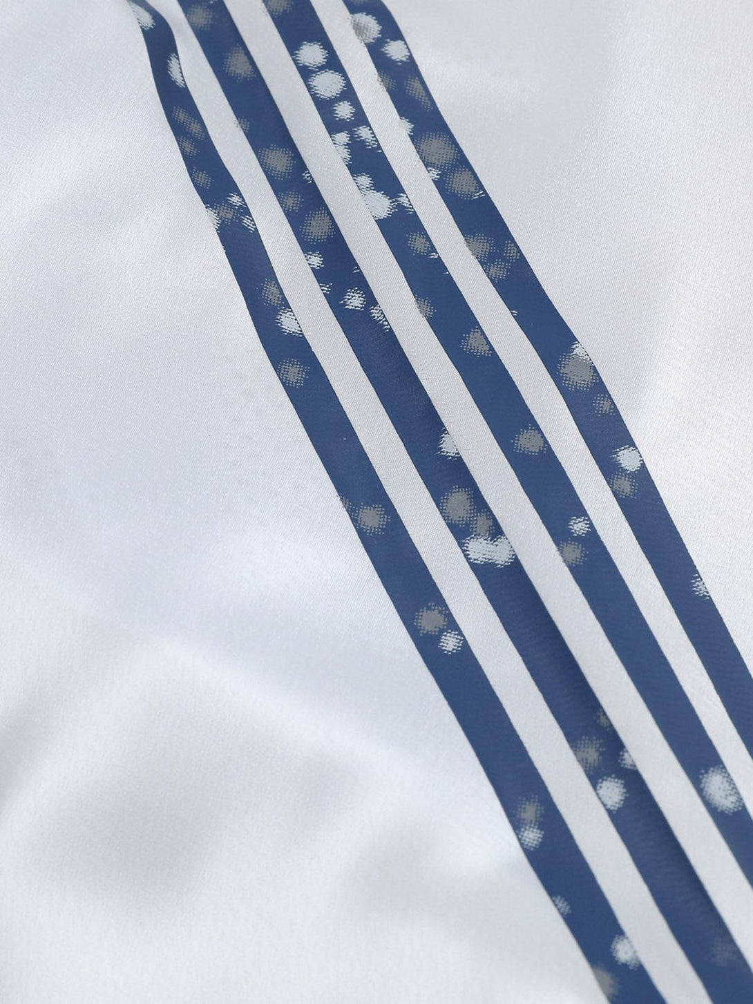 A detailed look at the blue-striped design on the white jersey T-shirt by TALISHKO.