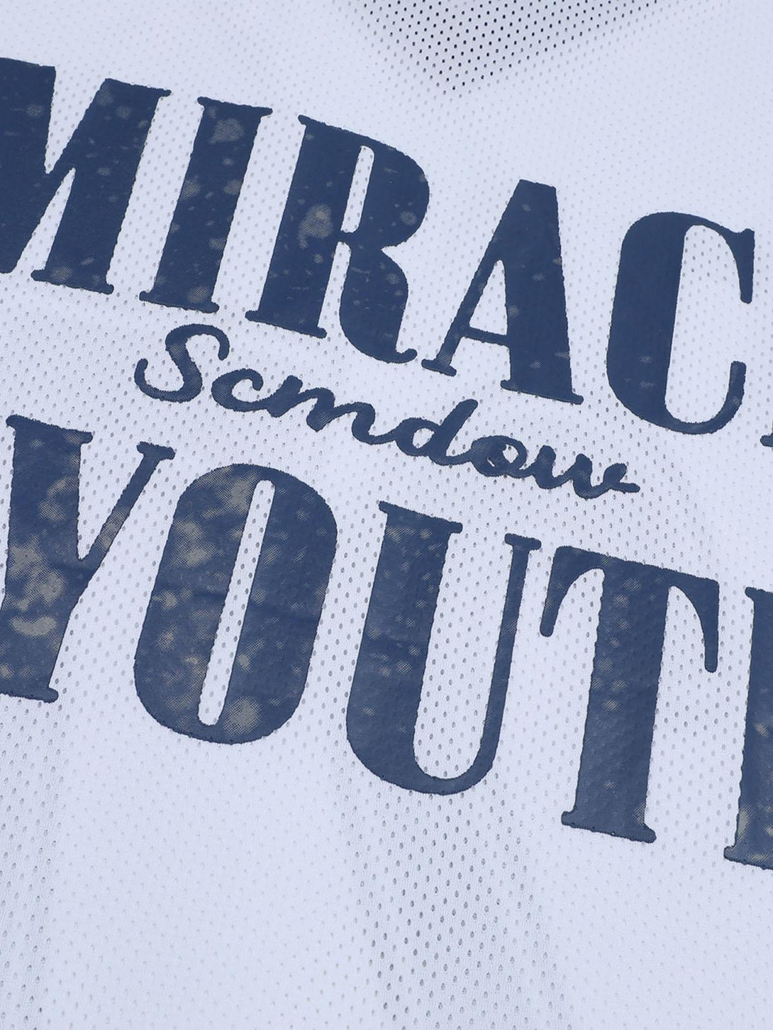 A close-up of the Miracle Youth text on a white jersey T-shirt by TALISHKO, showcasing texture.