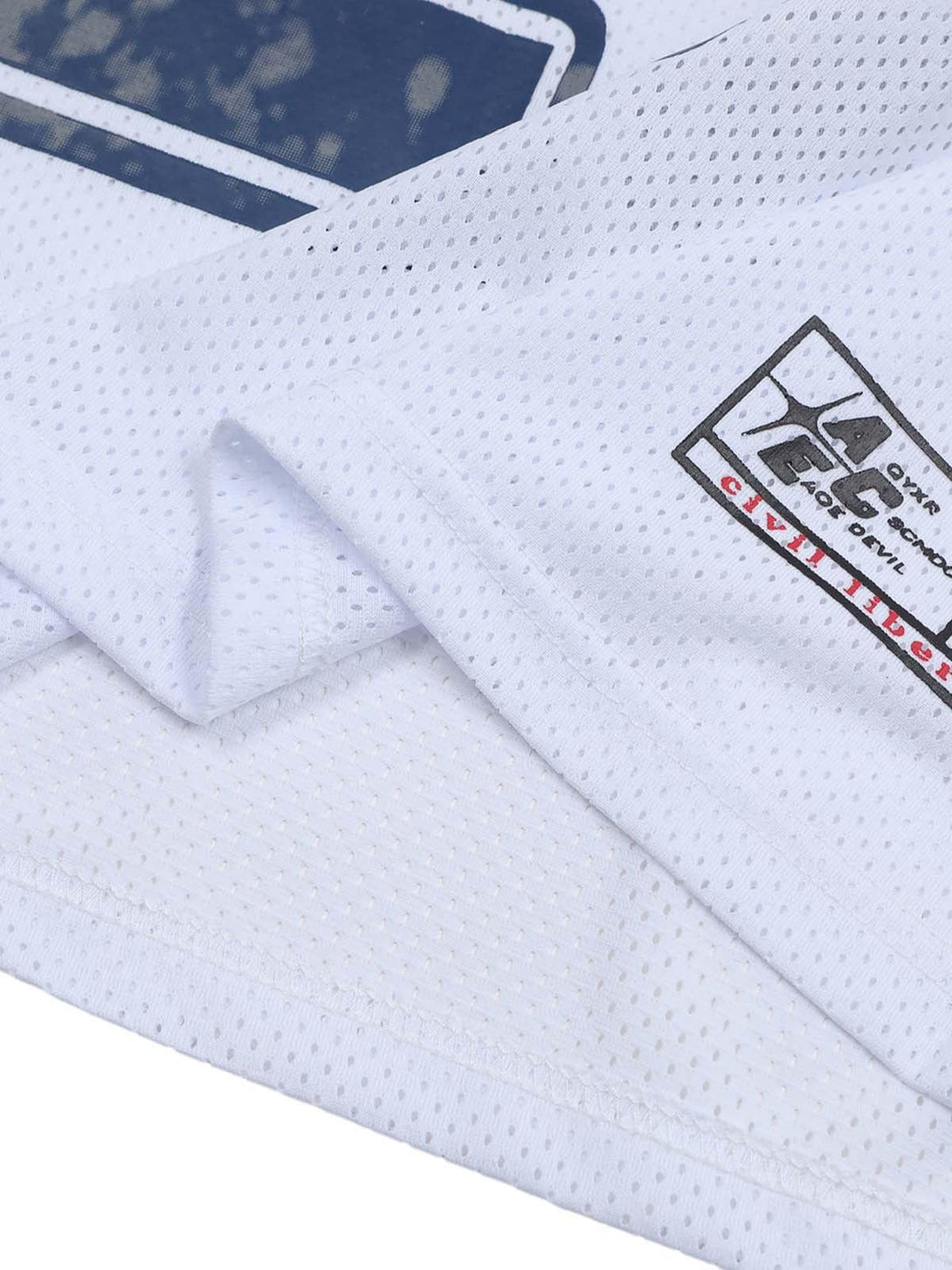 Intricate look at the textured fabric and logo detail on a white sports jersey by TALISHKO.