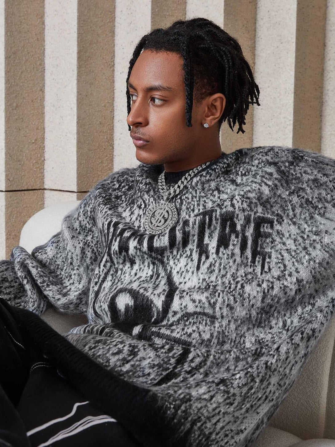 Model wearing TALISHKO's oversized spider sweater, showcasing its bold pattern and relaxed fit.